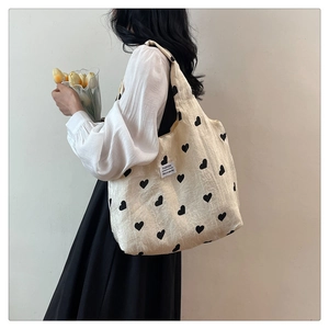 Close-up of heart print canvas tote bag with fashion label and soft texture detail