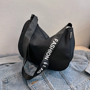 Minimalist black crescent canvas crossbody bag with wide fashion letter strap on denim