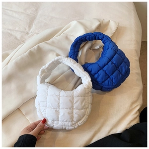 Close-up of quilted puff cloud bags in white and blue with pleated fabric texture