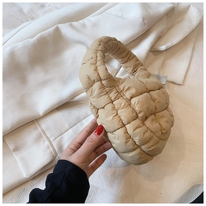 Detail view of beige quilted cloud bag showing soft padded nylon texture and puff design