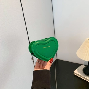 Mini emerald green heart-shaped shoulder bag with silver chain strap and gold logo
