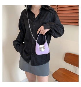 Detail of lavender saddle bag with silver bow accent and versatile chain strap
