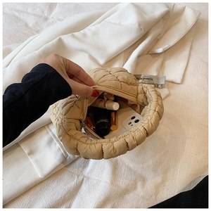 Detailed interior of beige quilted cloud bag showing storage space for phone and lipstick