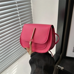 Women's rose red crossbody flap bag with golden tassel detail and shoulder strap