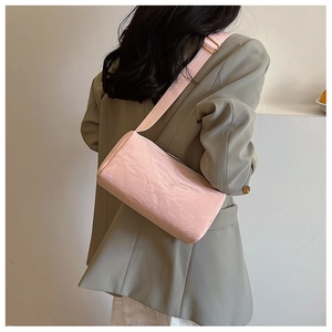 Pink cylinder shoulder bag with pleated texture shown in a casual lifestyle setting