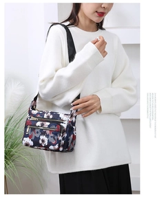 Floral print crossbody bag with multiple zip compartments and adjustable strap