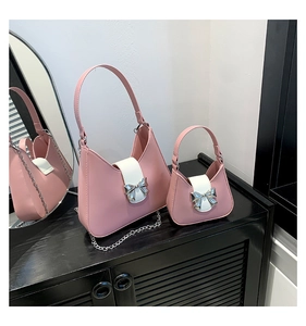Detail view of pink and white saddle bag set with silver bow buckle and chain strap