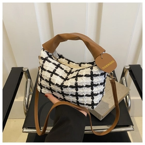 Detail of plaid woven small square bag with brown ruched handle and heart-shaped tag