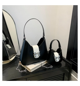 Detailed view of black and white saddle bags with silver bow metal clasp set on books