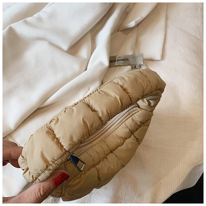 Detailed close-up of quilted beige puff cloud bag with silver zipper and puffy texture