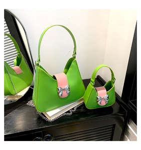 Detail of candy-colored saddle bags with pink leather flaps and silver bow metal buckles