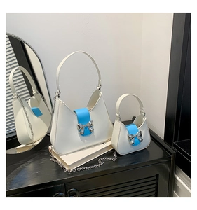 Macro view of cream saddle bags with blue magnetic flaps and silver metal bow accents
