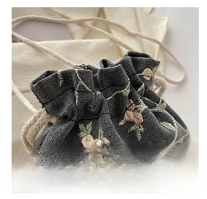 Détail du sac seau à cordon avec broderie florale rose et texture en résille
