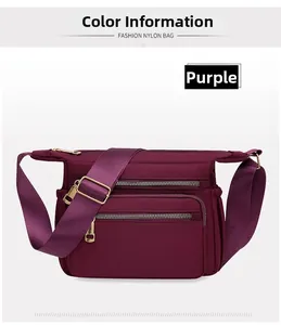 Detail view of the purple nylon crossbody bag showing multiple zippers and gold hardware