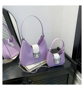 Detail of lilac and white leather saddle bag set with shiny silver metal bow clasp