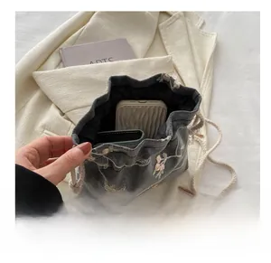 Détail montrant la capacité de stockage du sac seau à cordon avec broderie florale