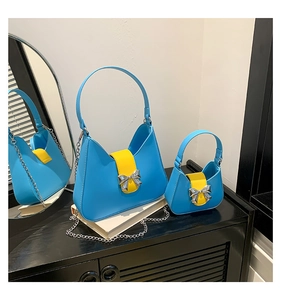 Detail view of light blue saddle bags with yellow flaps and silver bow metal charms