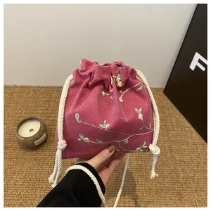 Broderie florale détaillée sur petit sac seau rose avec fermeture par cordon coton