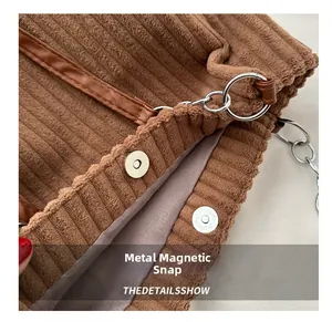 Close-up of brown corduroy tote bag showing the magnetic metal buckle and inner lining