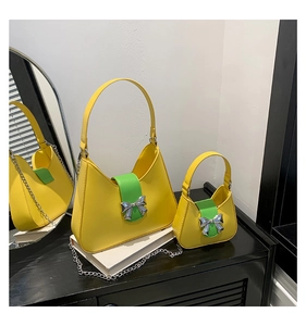 Detail of yellow saddle bag set with green strap and silver bow buckle on mirror