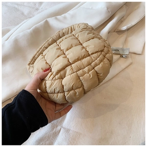 Close-up of beige quilted cloud bag texture and fluffy grid pattern on puffer handbag