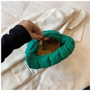 Detail view of the bright green quilted bubble bag with smooth zipper and beige lining