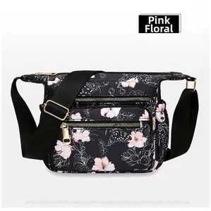 Detailed view of black nylon floral bag with multiple zip pockets and pink butterfly print