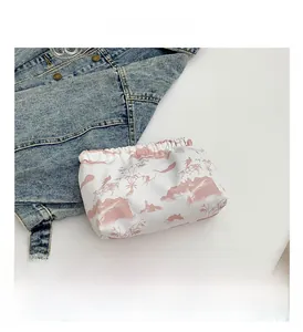 Detail view of nylon pouch with traditional pink landscape scenery and bird patterns
