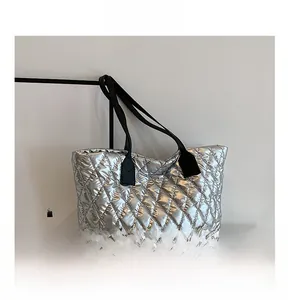 Détails du sac cabas matelassé argenté avec texture métallique et fines anses noires