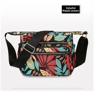 Detail view of colorful maple leaf print nylon bag with multiple zipper compartments