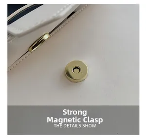 Macro view of strong magnetic closure on beige crossbody bag with lychee texture