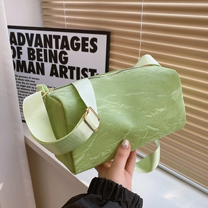 Minimalist light green cylinder shoulder bag with artistic wrinkled texture and wide strap
