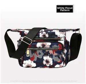 Detail view of floral nylon crossbody bag with multiple pockets and adjustable strap