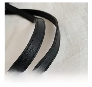 Détail de la poignée de sac à main en cuir noir avec coutures doubles renforcées