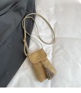Détail d'un mini sac bandoulière en paille tissée avec de longues franges déco