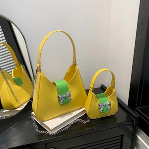 Fashionable yellow leather saddle bag with green strap and silver bow decoration