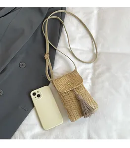Détail du sac à bandoulière en paille tissée avec pompon et comparaison de taille