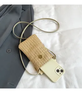 Détail du sac de téléphone en paille tressée montrant l'espace pour grands smartphones