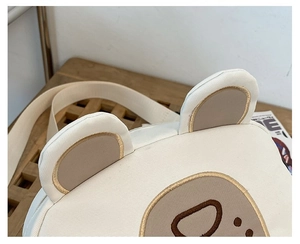 Close-up of cute cartoon bear canvas bag with premium gold thread embroidery details
