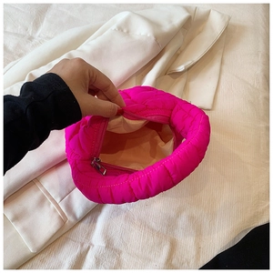 Magenta quilted cloud bag detail showing metallic zipper and soft beige lining