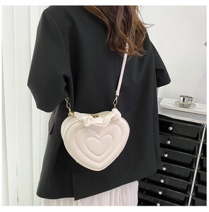 Detail of heart-shaped crossbody bag featuring pleated cloud edges and cream PU leather