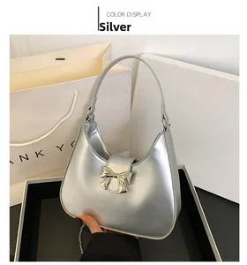 Close-up of a silver hobo bag with metallic finish and bow buckle detail