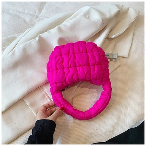 Detail of square quilted hot pink nylon puffy handbag with padded handle for women