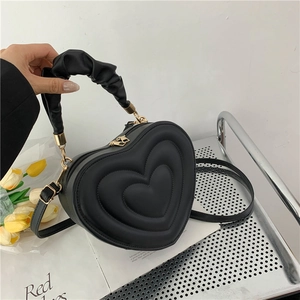 Chic black heart-shaped quilted handbag with unique pleated handle and gold hardware