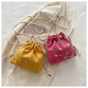 Vue détaillée de la broderie florale et du cordon sur les sacs seaux pastel