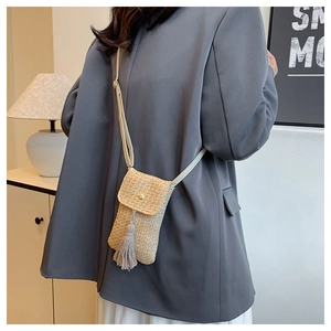 Détails de la texture du sac en paille avec boucle dorée et élégant pompon décoratif