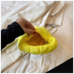 Detail view of heart-shaped quilted makeup bag in bright yellow bubble fabric with zipper