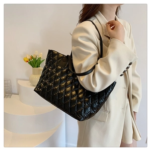 Vue détaillée d'un grand sac cabas noir matelassé avec motif à carreaux et bandoulière