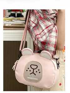 Detailed view of the pink cartoon bear messenger bag with embroidery and adjustable strap