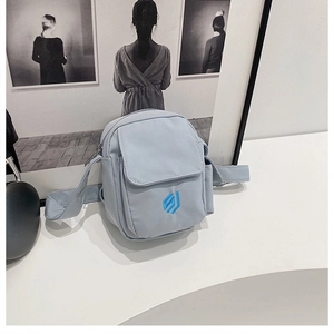 Detailansicht hellblaue Umhängetasche aus wasserfestem Nylon mit Stickerei-Logo